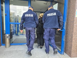 Policjanci wprowadzają do budynku zatrzymaną