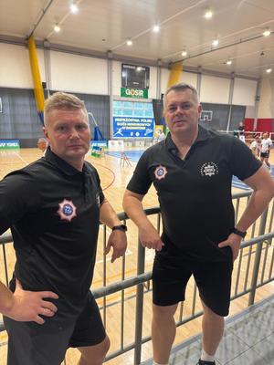 Dwaj mężczyźni w strojach sportowych pozują do zdjęcia
