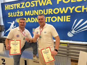 Dwaj mężczyźni z medalami pozują do zdjęcia