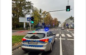 Policyjny radiowóz stoi przed przejściem dla pieszych w miejscu zdarzenia drogowego