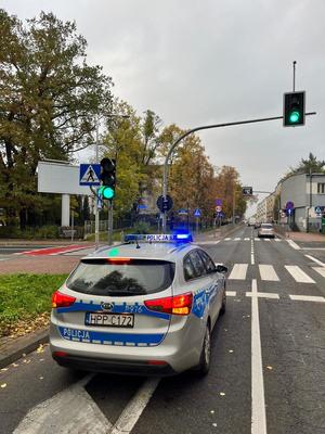 Miejsce zdarzenia drogowego gdzie policyjny radiowóz stoi przed przejściem dla pieszych