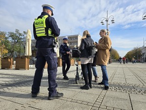 Policjanci kontrolują użytkownika hulajnogi a dziennikarze nagrywają ich działania