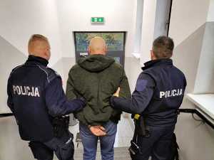 Policjanci doprowadzają zatrzymanego