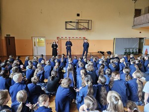 Dzieci słuchają tego, co mówią policjanci podczas prelekcji