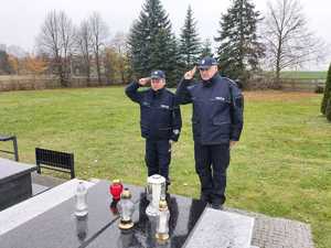 Policjanci oddają honor przy grobie