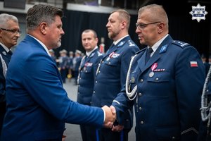 Mężczyzna podaje rękę policjantowi i składa mu gratulacje