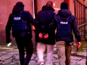 Policjanci doprowadzają zatrzymanego