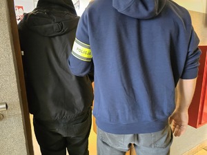 Policjant doprowadza zatrzymanego do pokoju służbowego