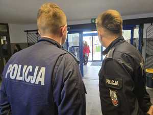 Policjanci stoją przy wejściu do komendy