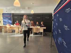 Kobieta wychodzi z sali w której siedzą osoby weryfikujące uczestników