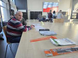 Mężczyźni siedzą przy stoliku na którym leży wyposażenie