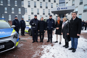 Uczestnicy pozują o zdjęcia przy radiowozie