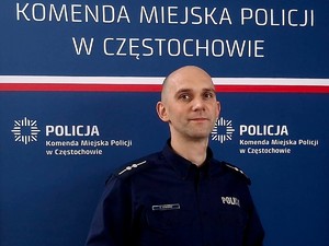 Policjant pozuje przy ściance