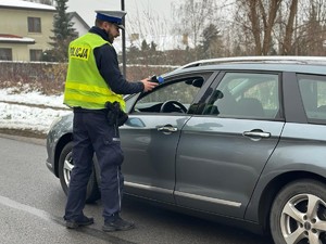 Policjant bada stan trzeźwości kierującego osobówką