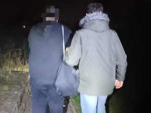 Nieumundurowany policjant doprowadza zatrzymanego