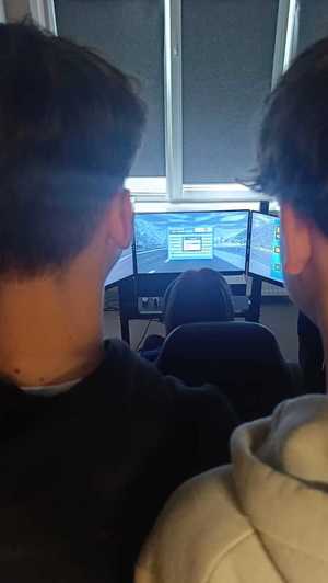 Dwóch uczniów stoi przy wyświetlaczu symulatora