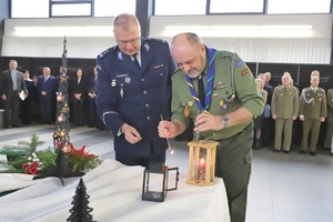 Komendant i harcerz przekazują sobie symboliczne światełko