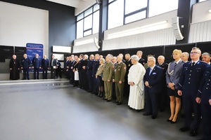 Zgromadzeni goście stoją w auli komendy