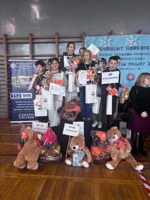 Nagrodzone dzieci pozują do zdjęcia z podium