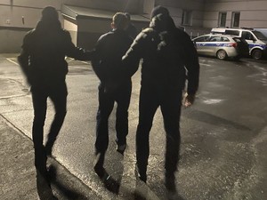 Nieumundurowani policjanci doprowadzają zatrzymanego