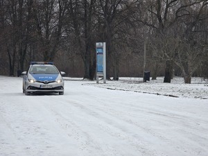Policyjny radiowóz jedzie po zaśnieżonej drodze