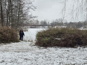 Policyjny patrol kontroluje zamarznięty zbiornik wodny