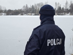 Policjant kontroluje zamarznięty zbiornik wodny