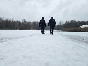 Policyjny patrol kontroluje zamarznięty zbiornik wodny