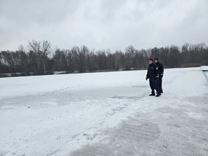 Policjanci rejon przy zamarzniętym zbiorniku wodnym