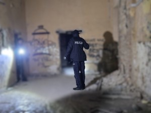 Policjant kontroluje pomieszczenia pustostanu