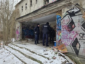 Policjant idzie przy opuszczonym budynku
