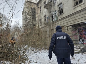 Policjant idzie przy opuszczonym budynku