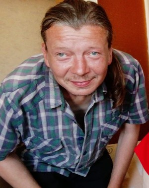 mężczyzna z lekkim zarostem i koszuli w kratę