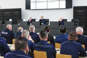 Policjanci siedzą w auli i słuchają tego, co mówi komendant