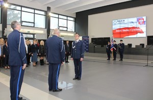 Dowódca uroczystości składa meldunek komendantowi, który wszedł do auli