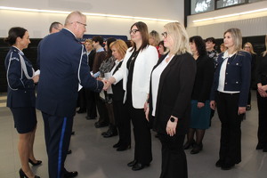 Komendant podaje rękę kobiecie, która stoi w szeregu pracowników cywilnych