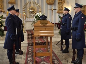 Trumna przy której stoi policyjna asysta