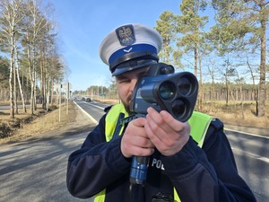 Policjant mierzy prędkość urządzeniem