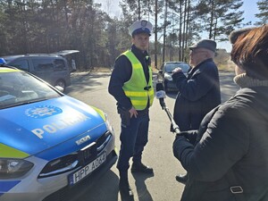 Policjant i dziennikarze rozmawiają z mężczyzną