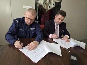 Komendant i rektor podpisują dokumenty przy stoliku