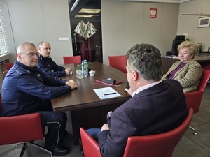 Dwóch policjantów rozmawia przy stoliku z kobieta i mężczyzną