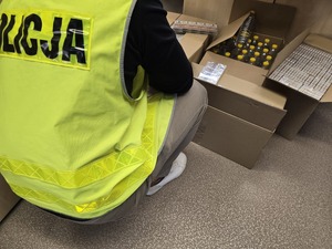 Policjant w kamizelce z napisem Policja zabezpiecza lewy towar