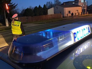 Policjantka na drodze unosi latarkę do gory