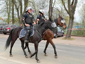 Policjanci na koniach patrolują rejon przy stadionie sportowym