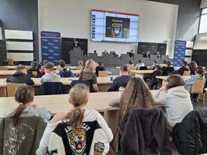 Uczestnicy w auli podczas konferencji słuchają tego, co mówi poicjant