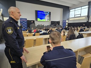 Strażnik miejski stoi przy policjancie, podczas konferencji