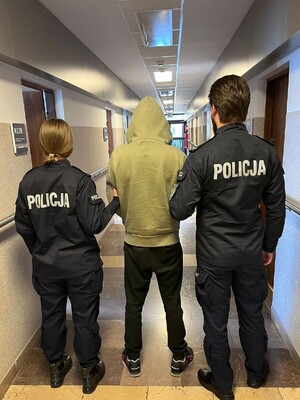 Policyjny patrol doprowadza zatrzymanego