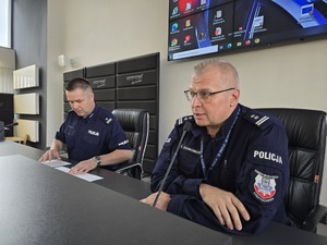 Komendant i naczelnik siedzą przy mikrofonach podczas turnieju w auli komendy
