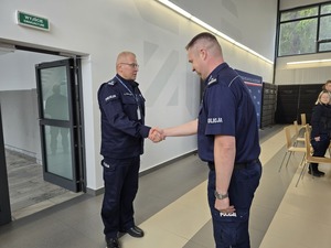 Naczelnik podaje komendantowi prawą dłoń po złożonym meldunku przy wejściu do auli