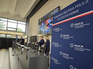 Policjanci z komisji stoją przy mównicy w auli